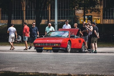 A group of enthusiasts gathered around a classic car.