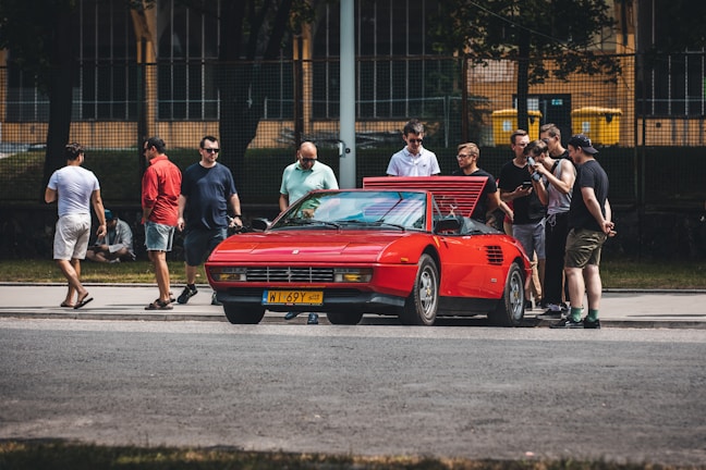 A group of car enthusiasts admiring a rare vehicle.