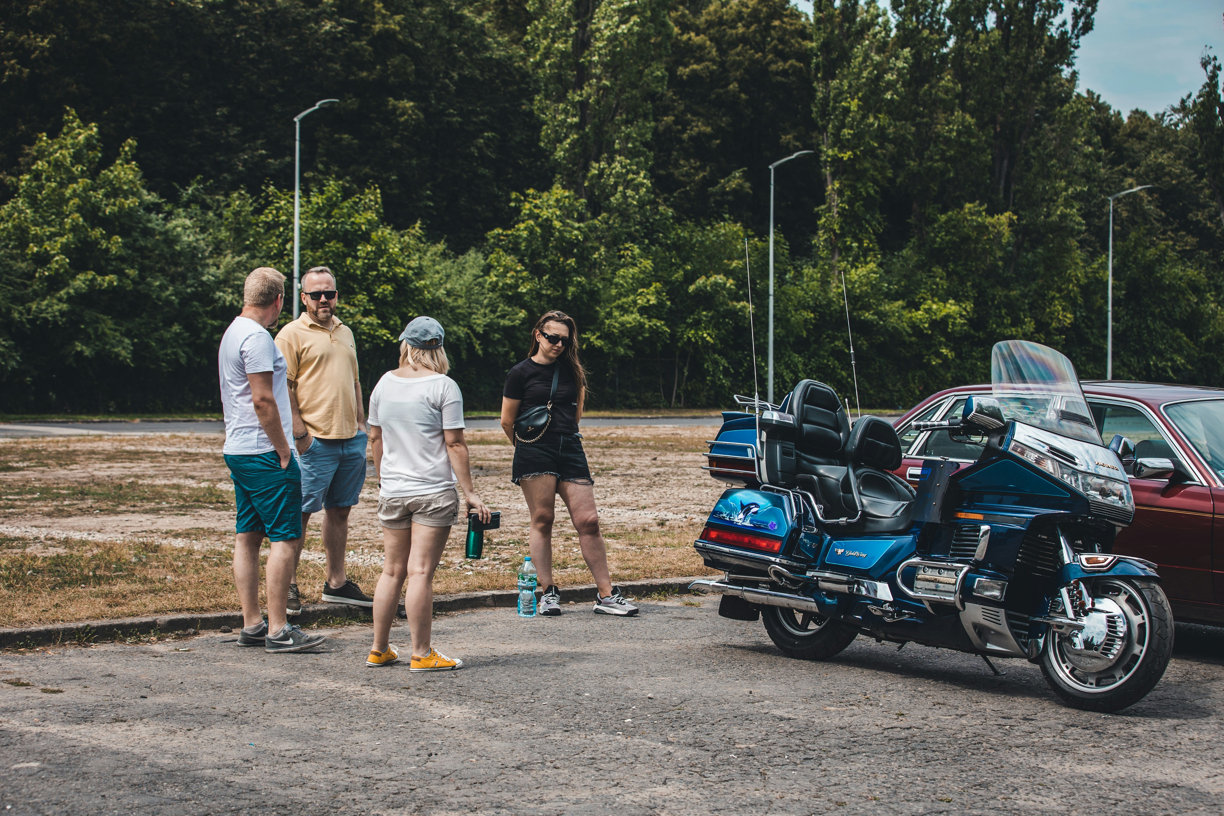 a group of people standing around a parked motorcycle