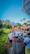 A joyful group of pilgrims walking together in traditional attire under a clear blue sky.