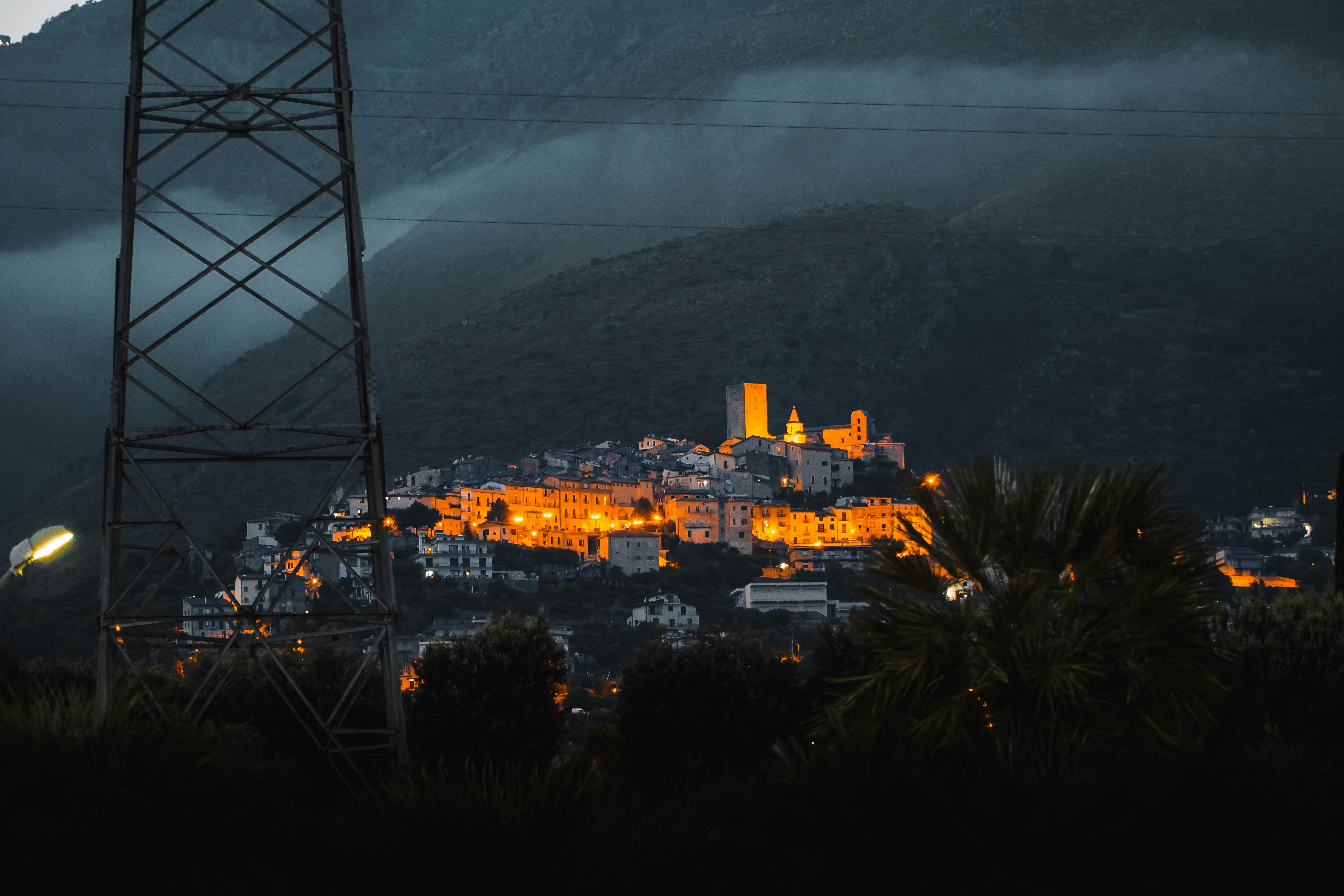 Eerie horror comedy atmosphere — dark misty village at night, candlelight, deep shadows, supernatural cinematic tension