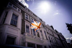 a flag flying in the wind in front of a building