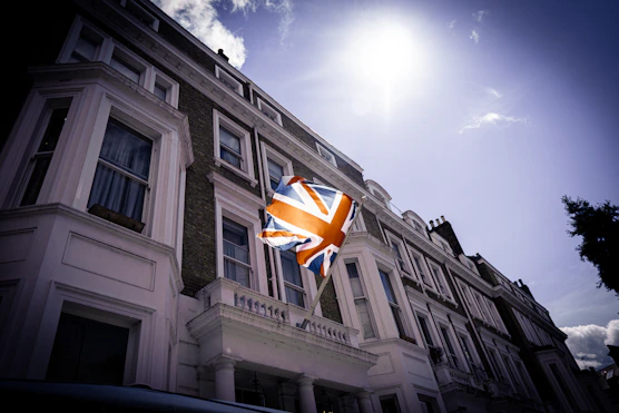 a flag flying in the wind in front of a building