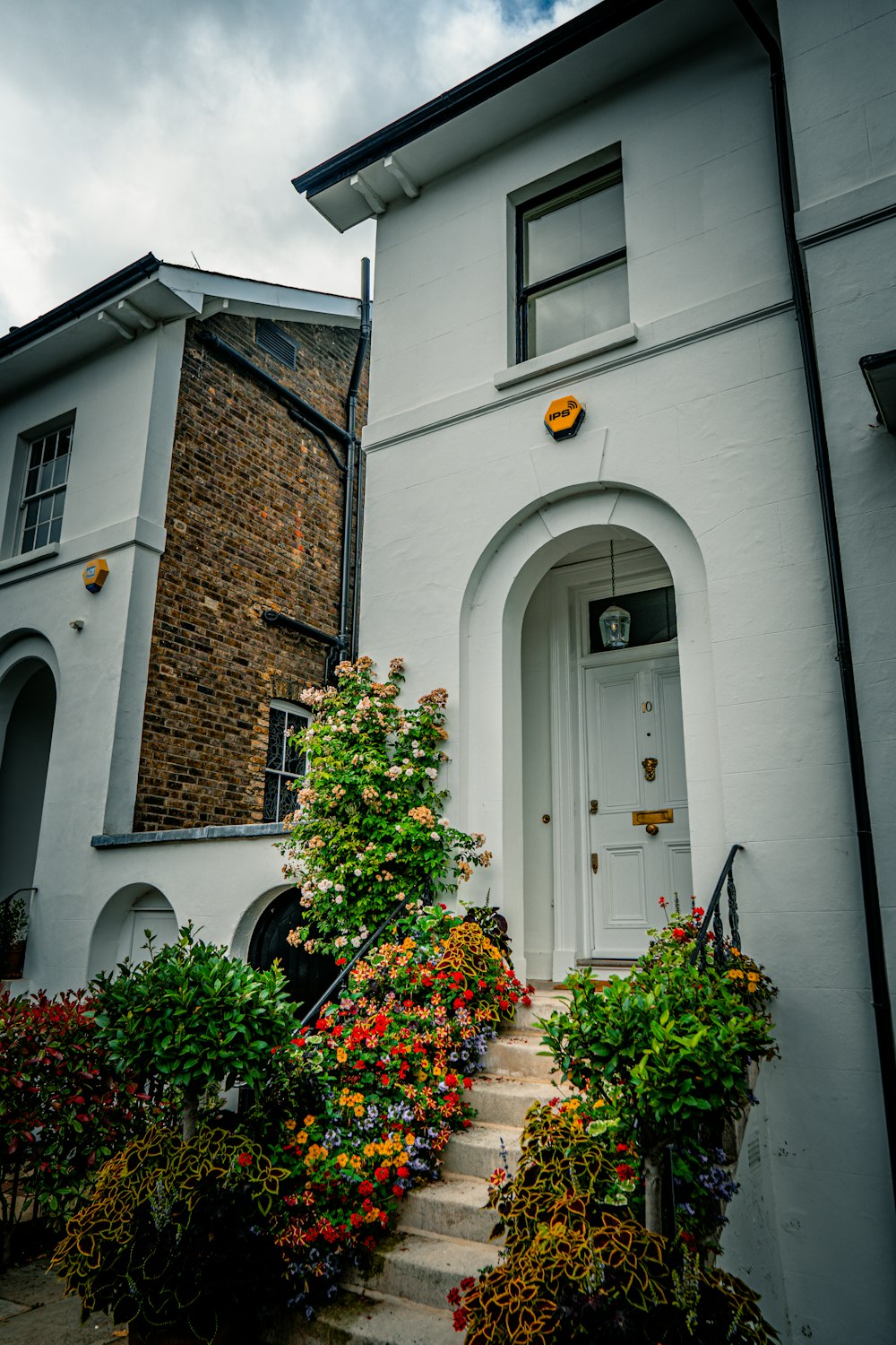 a white house with a white door surrounded by flowers