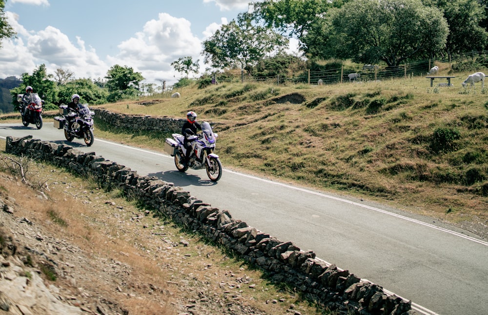 a group of people riding motorcycles down a road