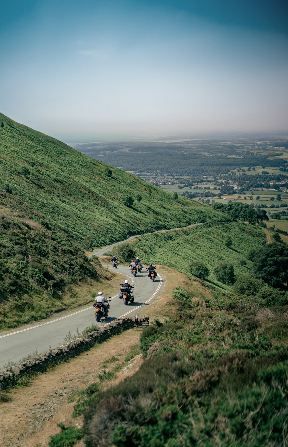 a group of people riding motorcycles down a curvy road