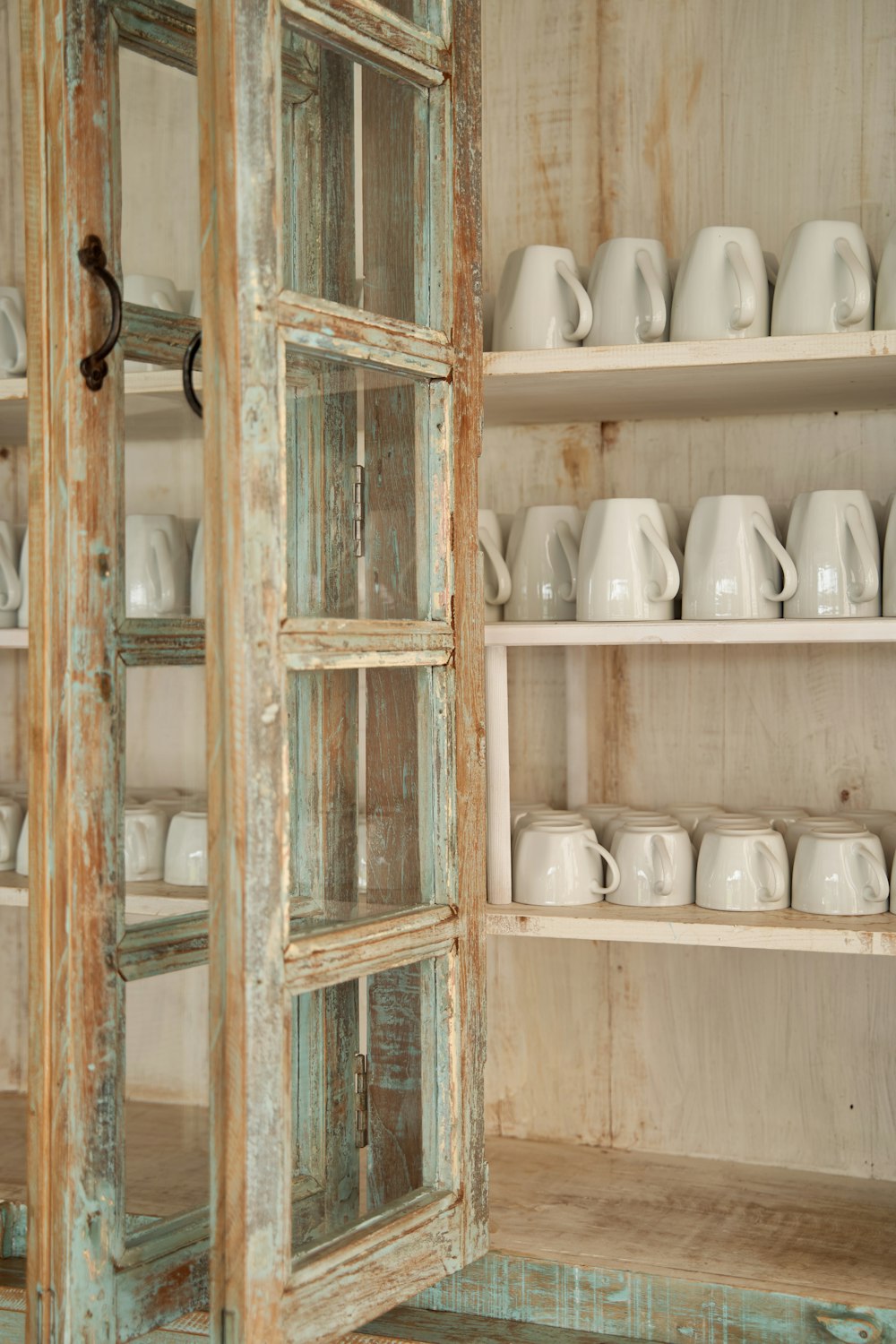 a cabinet filled with lots of white dishes