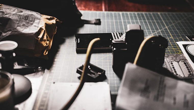 Creative workspace with matte forest green walls, camera gear, and notes scattered during a content creation session.