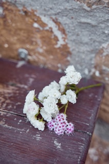 A delicate bouquet of aqua and white flowers resting on a wooden table