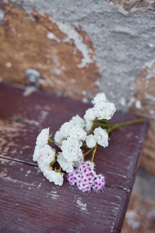 A delicate bouquet of wildflowers resting on a vintage wooden table.