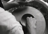 Hands shaping clay on a potter’s wheel, capturing the craft in motion.