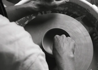 Close-up of hands molding clay, capturing the tactile nature of artistic creation.