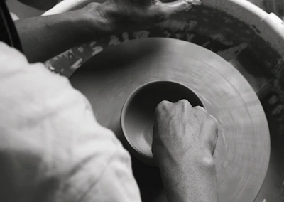 Hands shaping soft clay on a potter’s wheel, capturing the art of slow living.