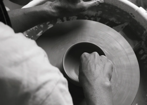 An artistic shot of hands molding clay on a pottery wheel, capturing motion.