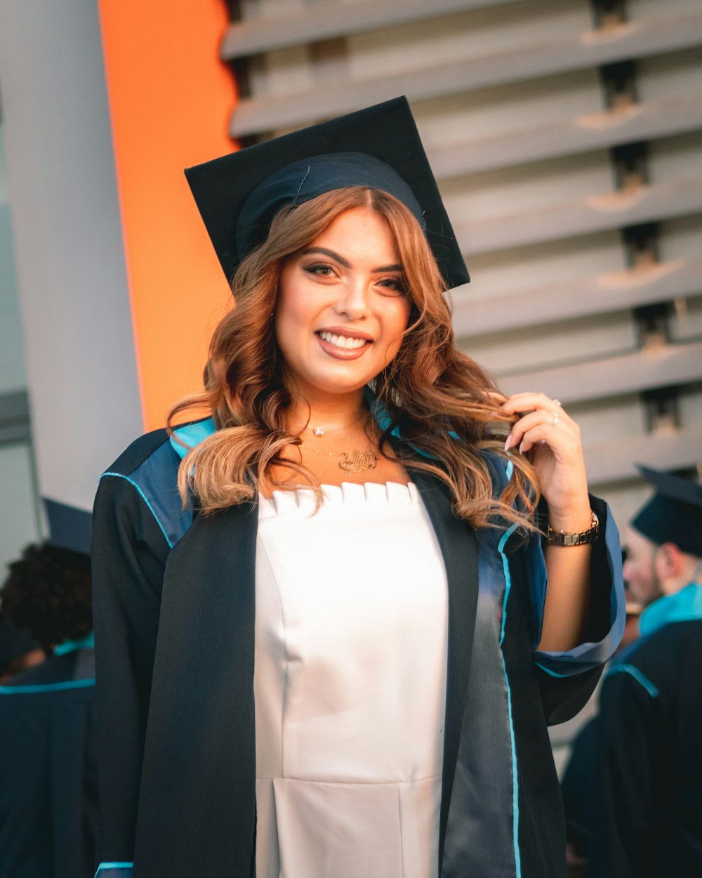 Una mujer con una gorra y bata de graduación