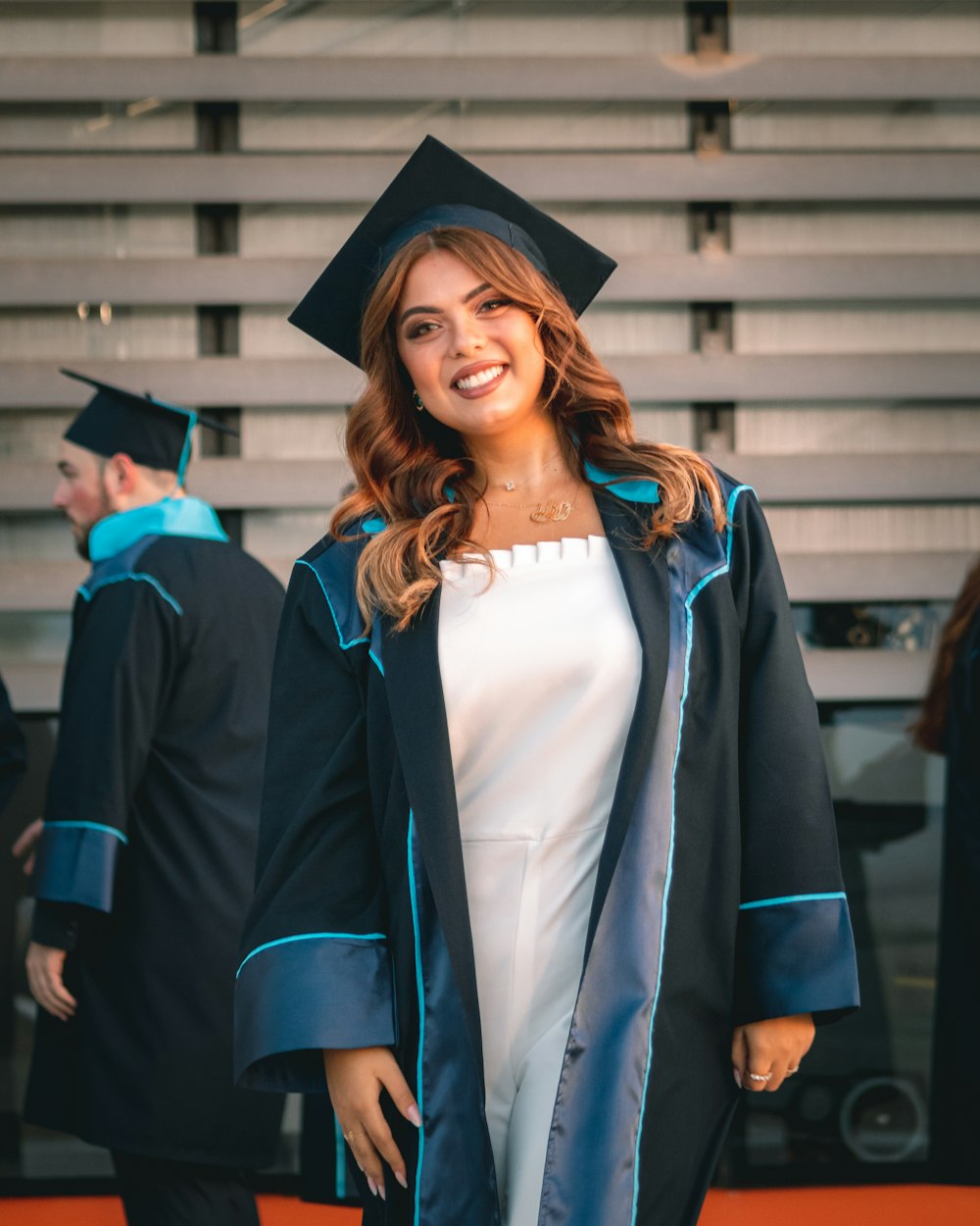 Una mujer con una gorra y bata de graduación