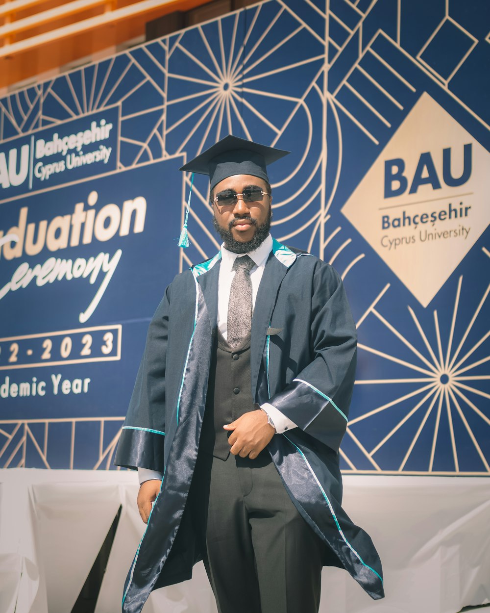 Un hombre con una gorra y bata de graduación