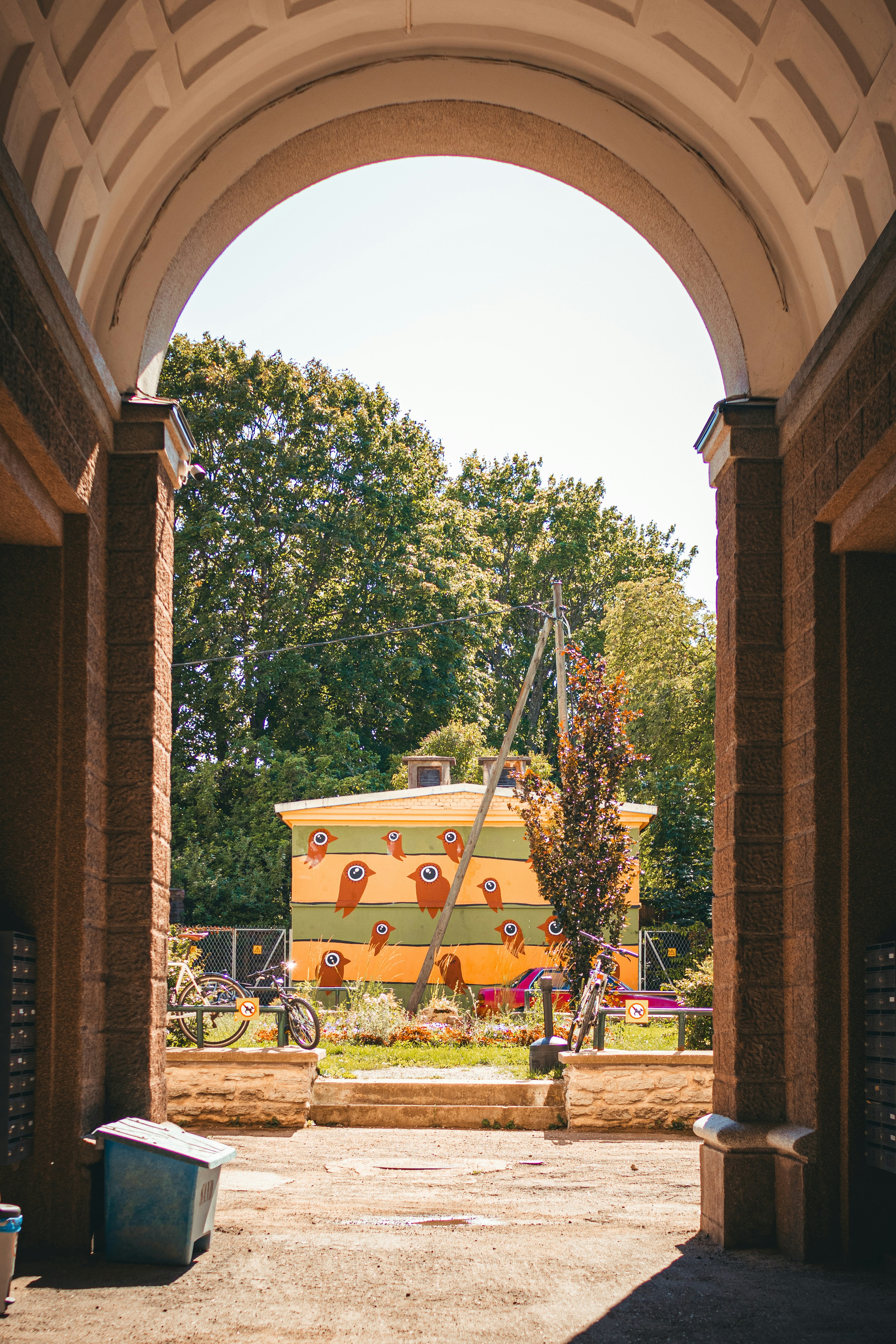 an archway leading to a building with a large orange truck in the background