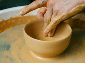 a person making a bowl on a pottery wheel
