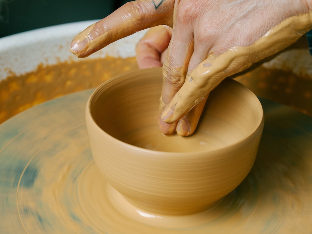 une personne fabriquant un bol sur un tour de poterie