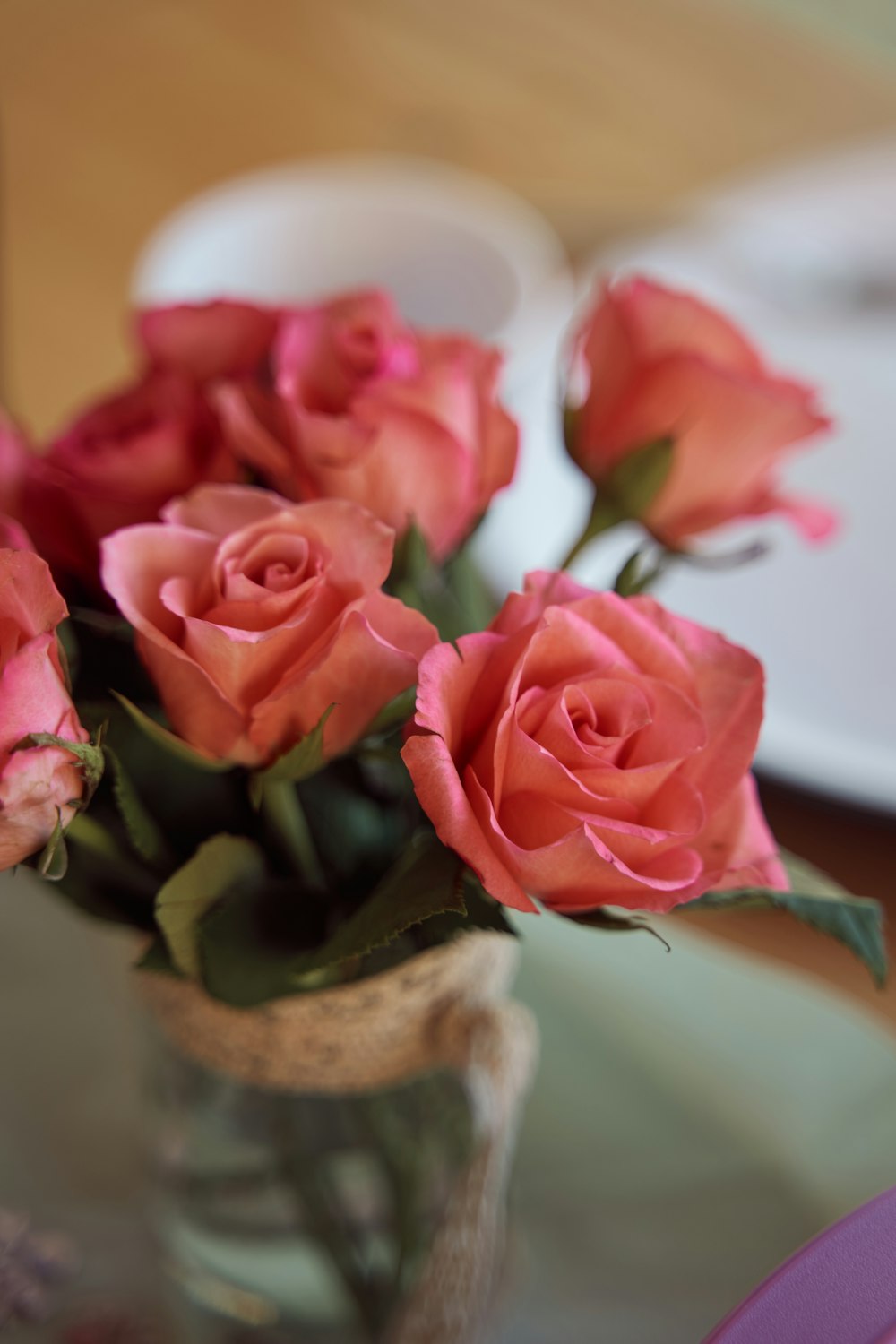 a vase filled with pink roses on top of a table