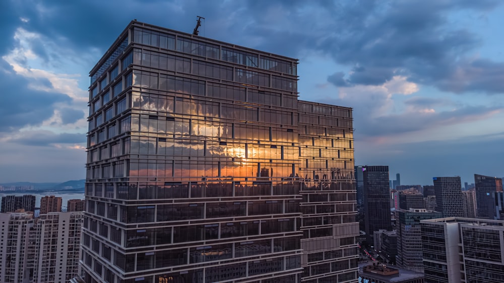 Un edificio muy alto con una puesta de sol al fondo