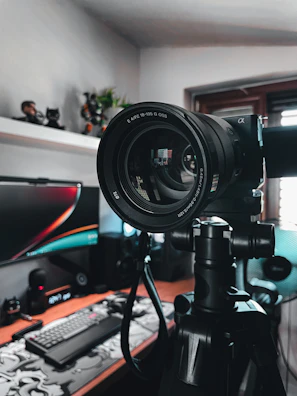 High-definition camera mounted on a tripod aimed at a podcasting desk.