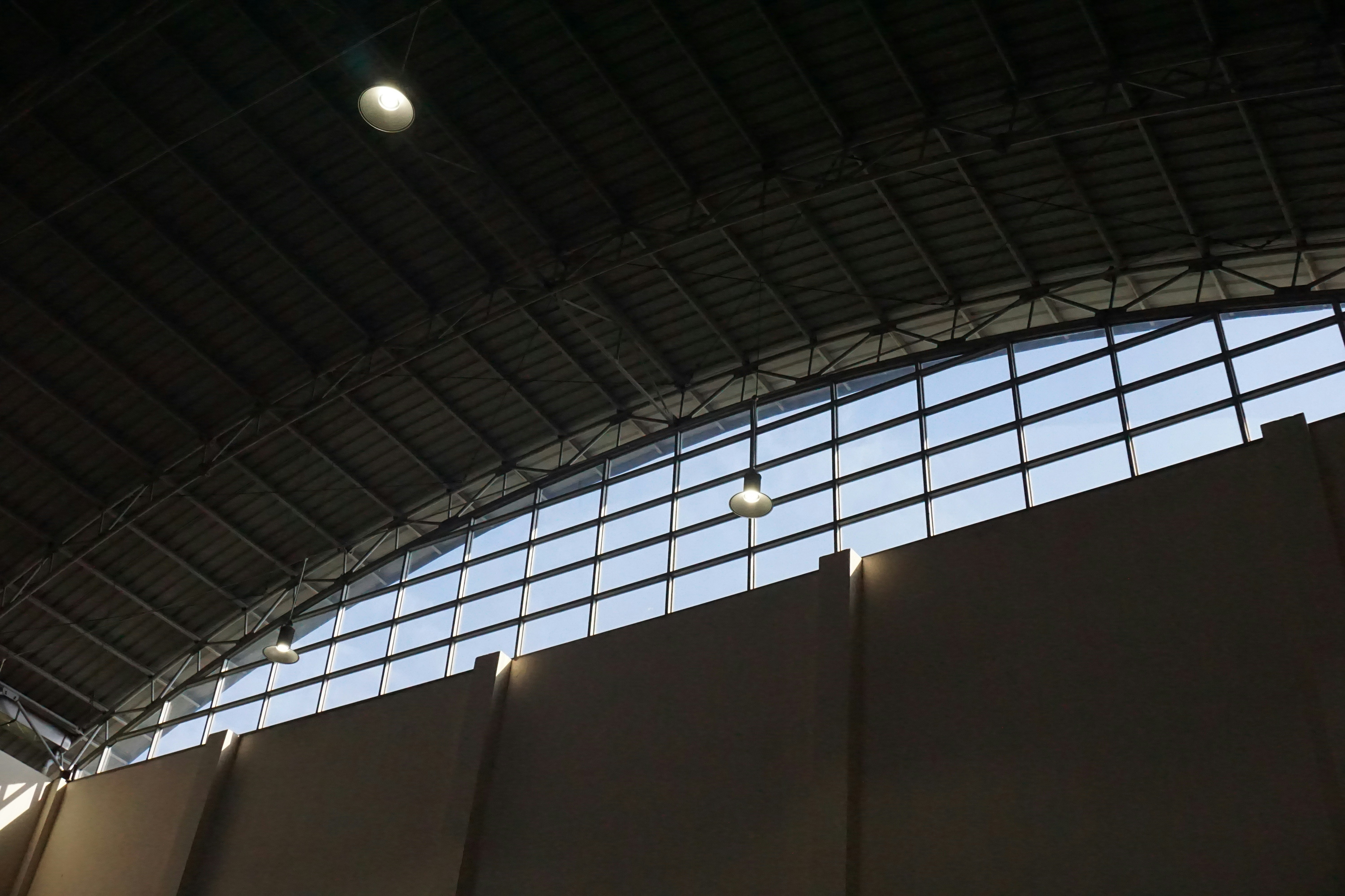 Professional craftsman working on ceiling installation, industrial lighting, dark workshop atmosphere