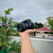 A happy customer holding a UBM Canon camera outdoors, smiling with a scenic background.