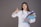 A woman in a white lab coat with a stethoscope around her neck is holding a stack of colorful folders in one hand and giving a thumbs-up with the other. She has long brown hair and is smiling confidently against a plain gray background.