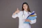 Smiling woman in her 30s holding a DNA test kit in an Abuja clinic.