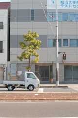Green and white branded Policontrol truck outside an office building