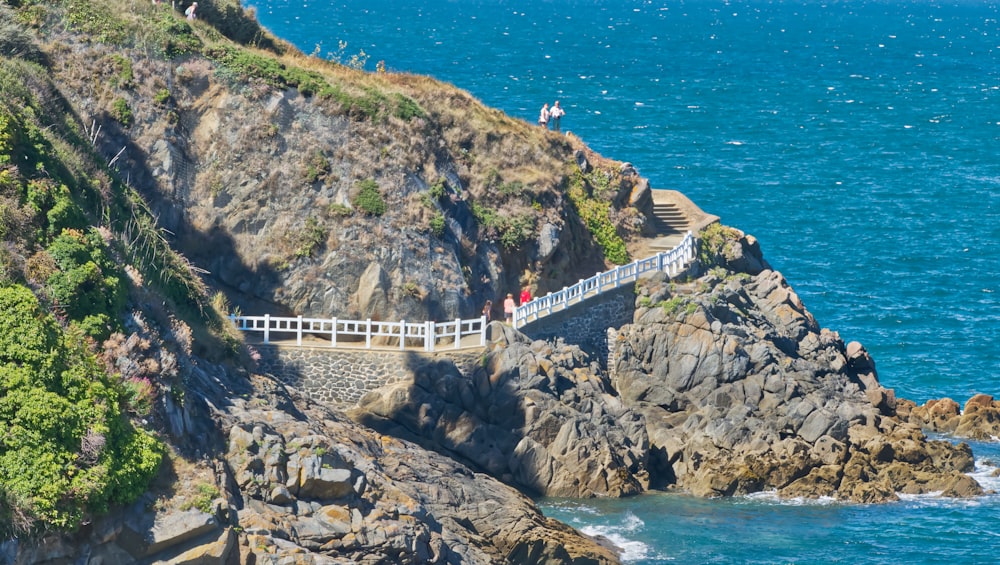 a group of people walking across a bridge over a body of water