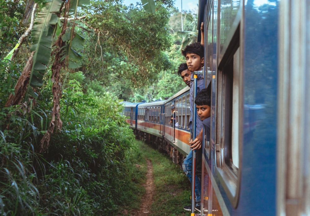 a group of people riding on the side of a train