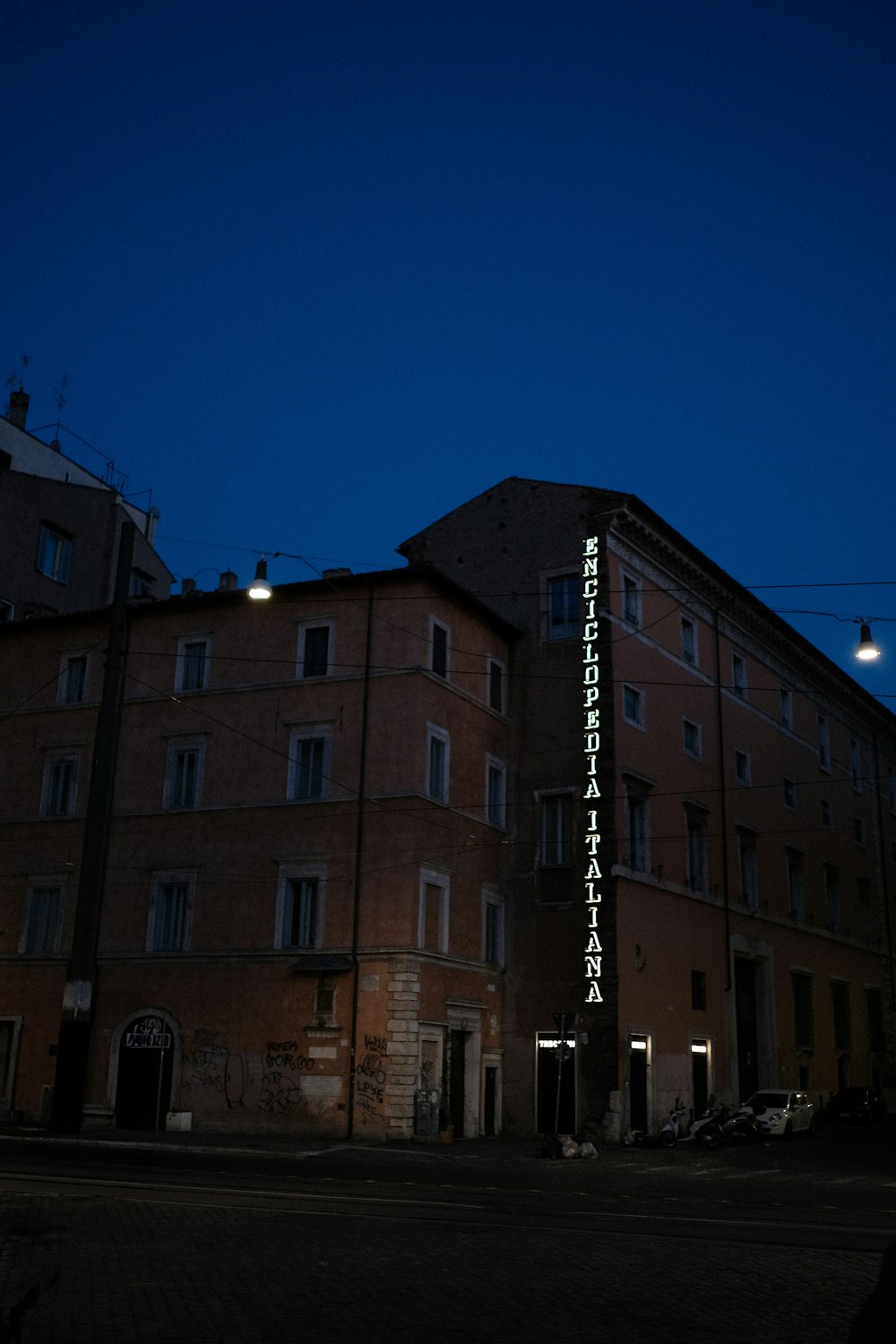 a tall building with a lit up sign in front of it