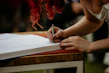 Close-up of a lecturer signing a freshly printed academic book.