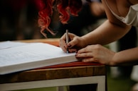 Close-up of hands signing a petition at a booth.