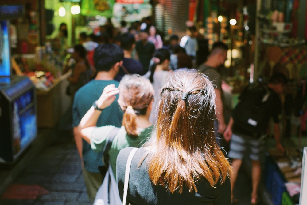 Un grupo de personas caminando por una calle junto a un televisor