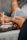 Close-up of hands working together over digital devices and notes.