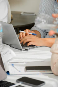 two people sitting at a table working on a laptop