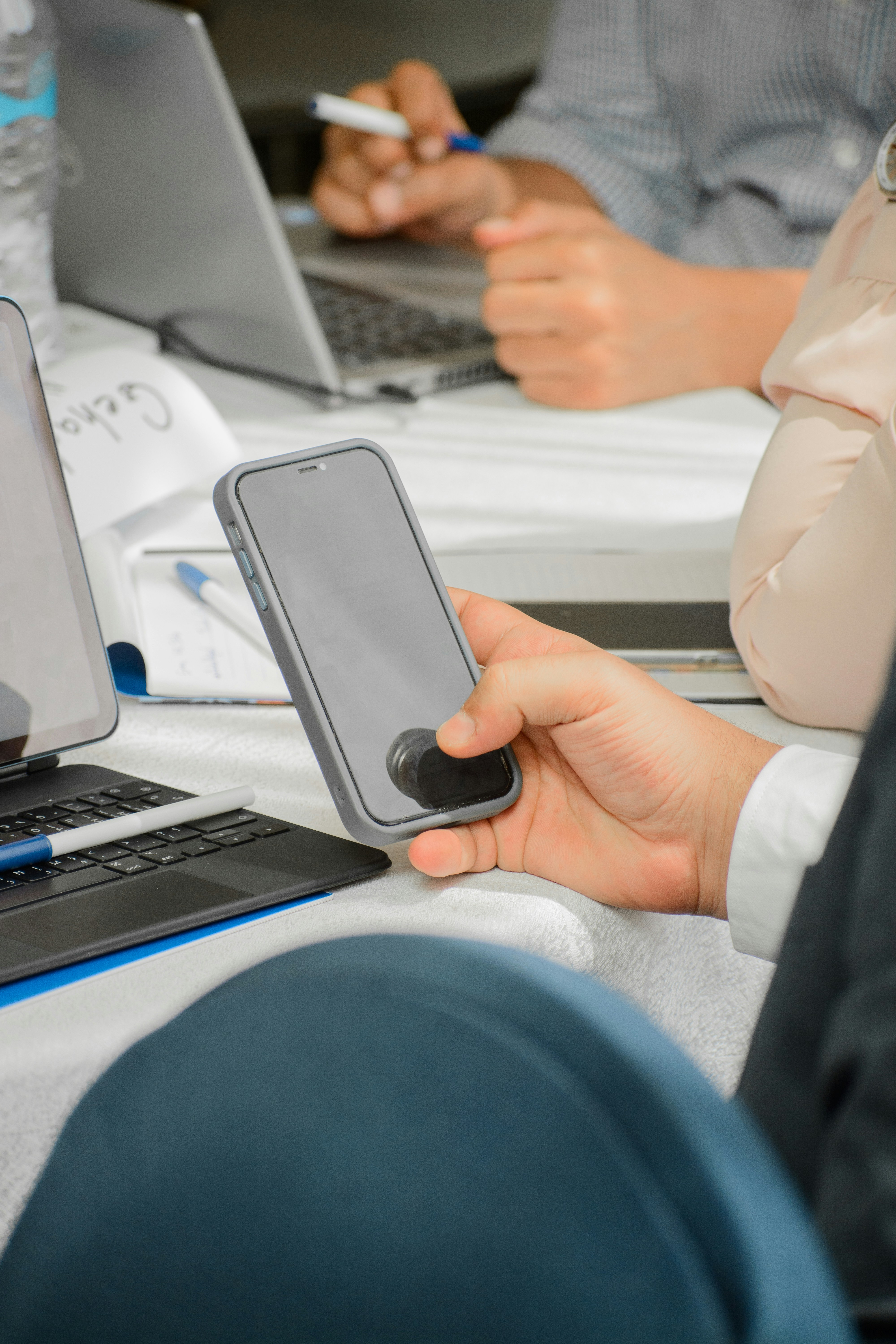 a person holding a cell phone in front of a laptop