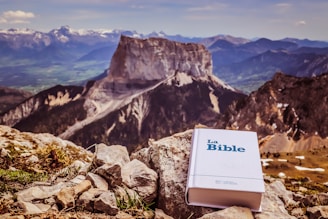 a bible sitting on top of a rocky mountain