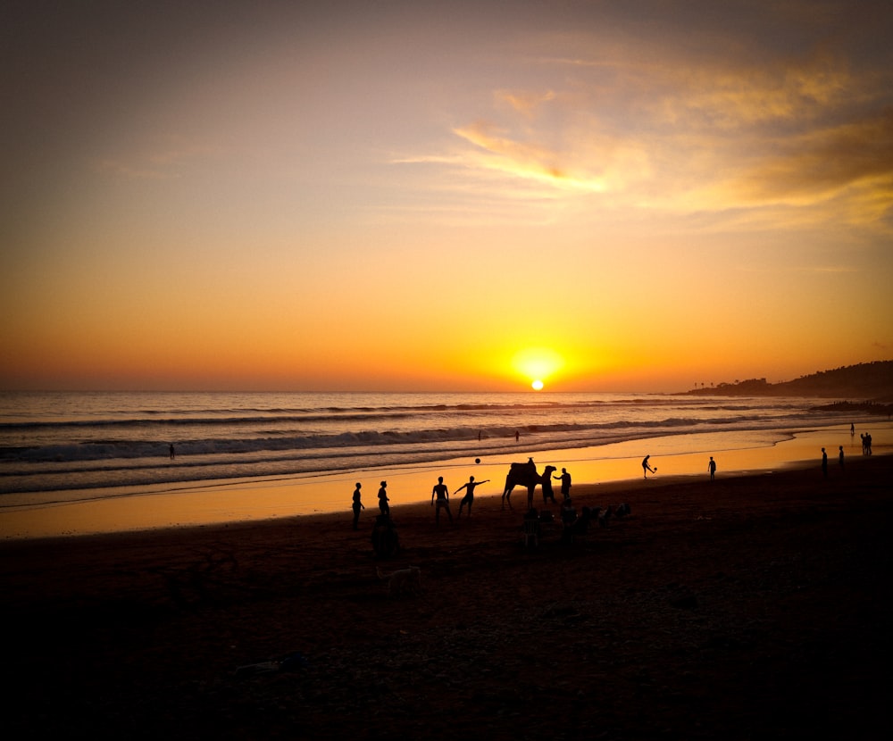 a group of people standing on top of a beach