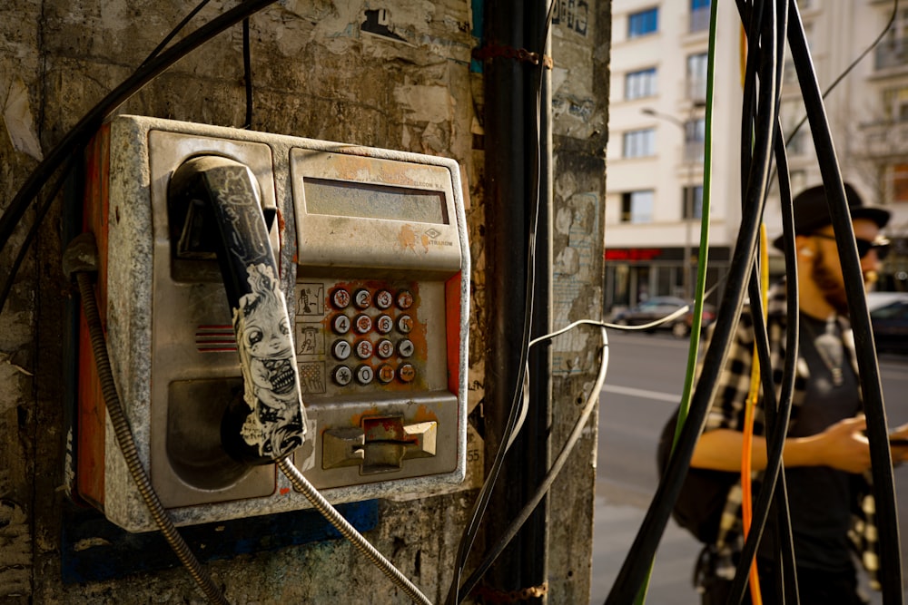 a man walking past an old pay phone