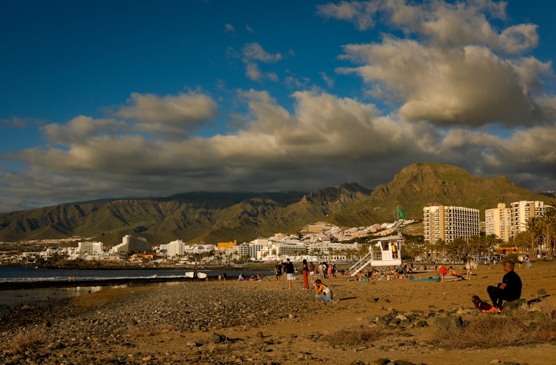 Un grupo de personas en una playa con montañas al fondo