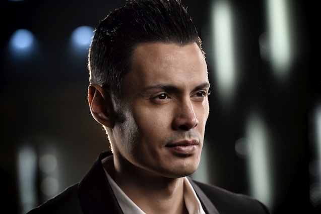 Professional portrait of Pedro Henrique Bermúdez in a modern office setting, wearing a dark suit and glasses.