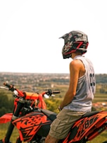 A rider wearing a helmet looking out over a vast desert landscape at sunset.