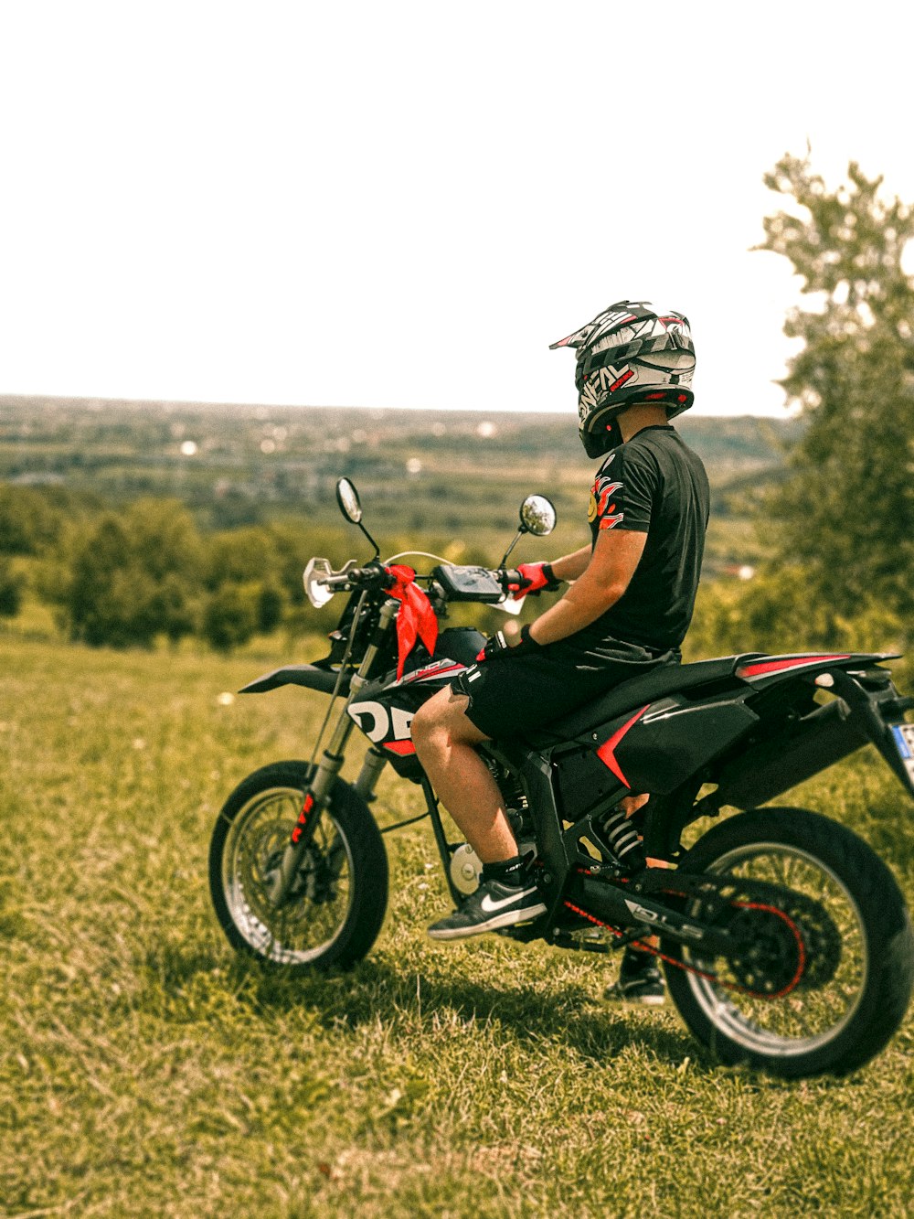 a man riding a motorcycle on top of a lush green field