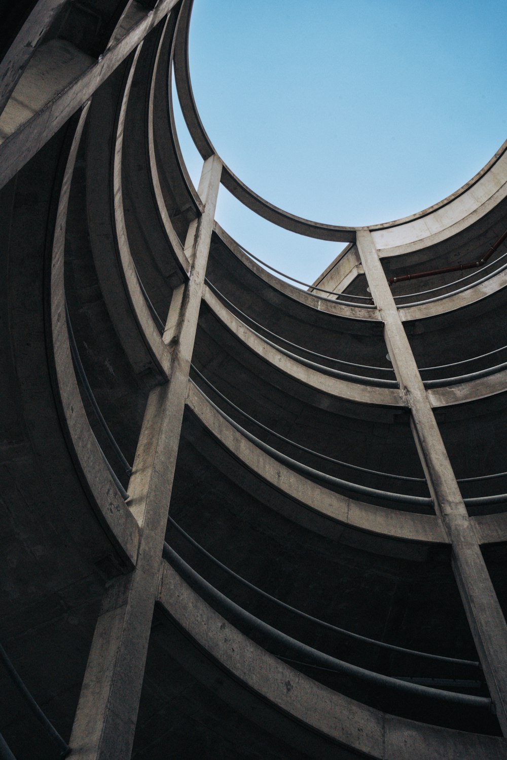 looking up at a circular concrete structure with a blue sky in the background