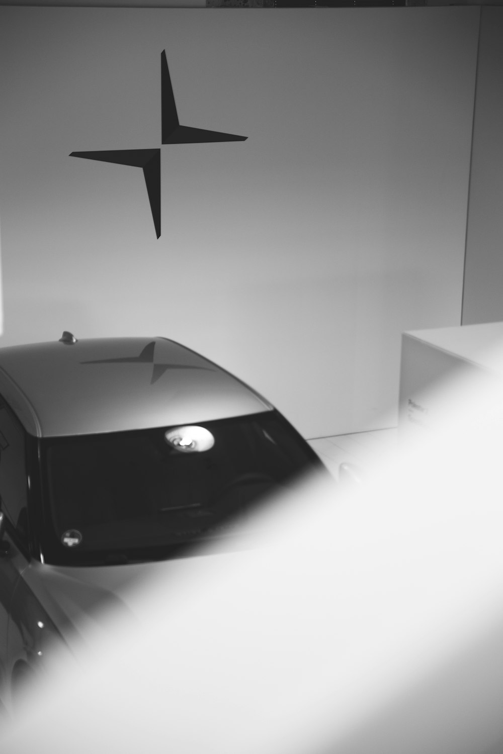 a black and white photo of a car in a showroom